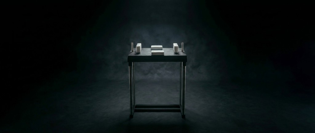 Legacy II arm wrestling table with white pads in a dark studio